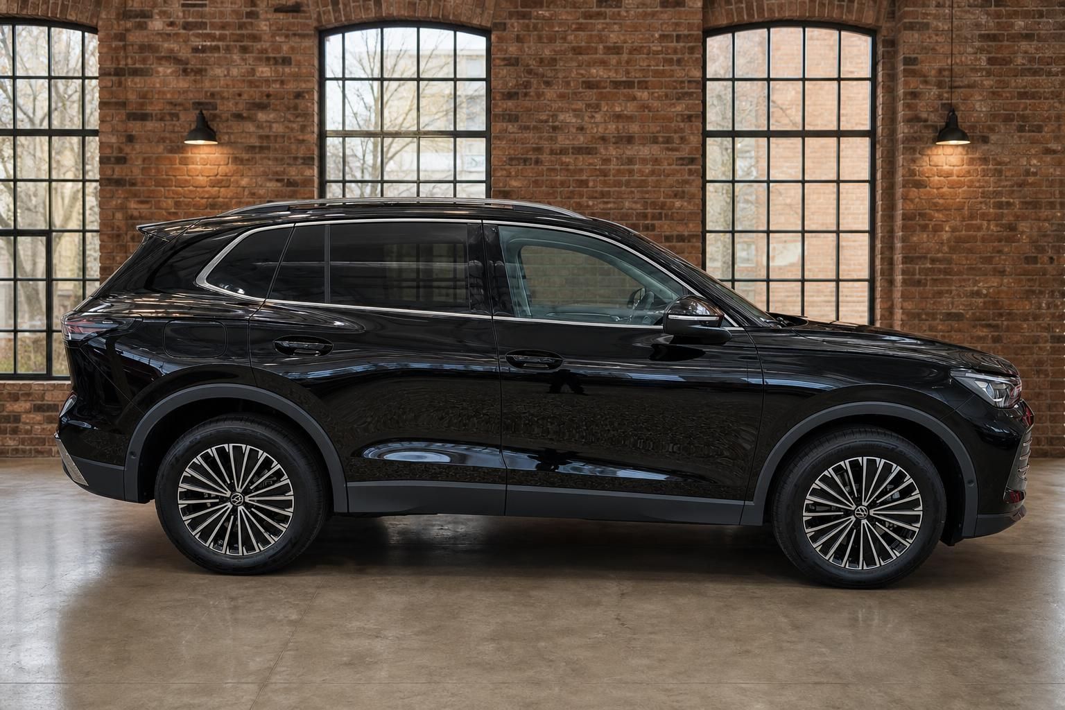 VW Tiguan schwarz Seitenansicht in moderner Industriehalle