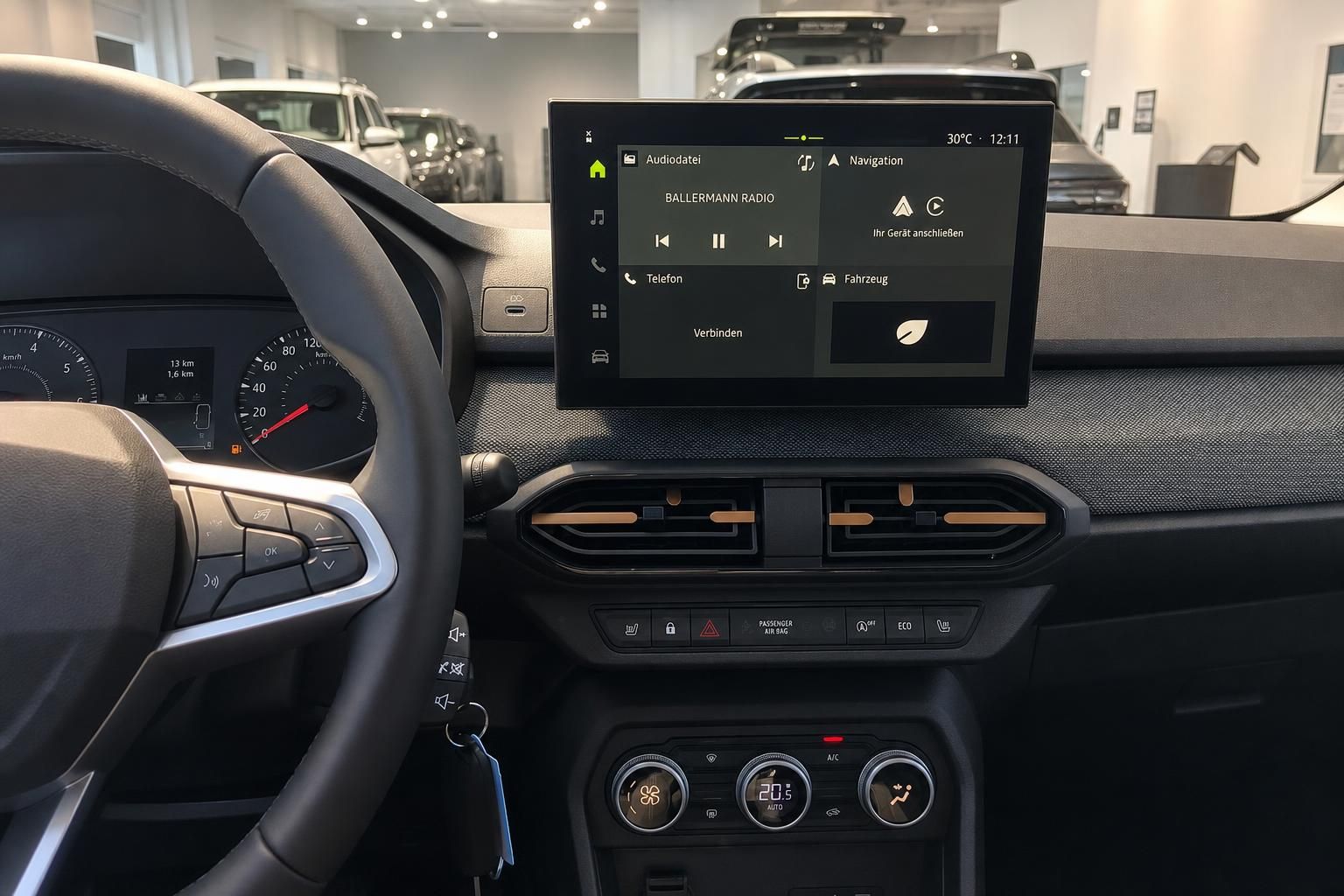 Blick auf Lenkrad, Tacho und Touchscreen im Fahrzeuginnenraum