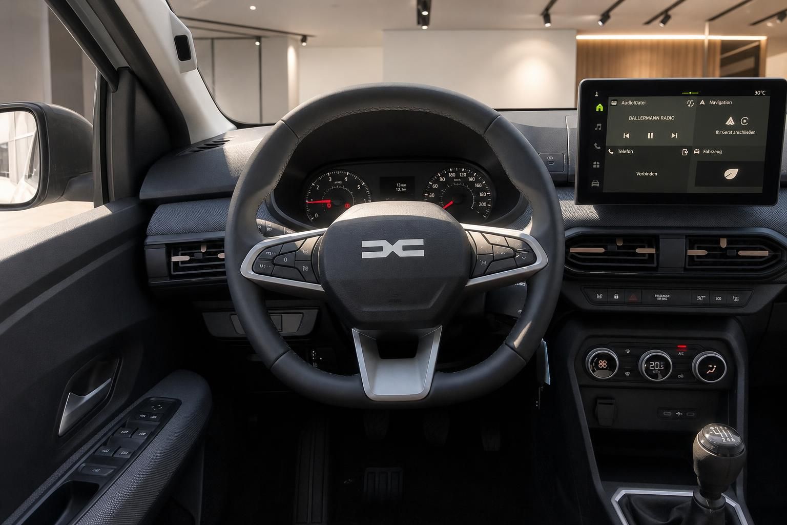 Cockpit mit Lenkrad, Tacho und Infotainment-Display im Fahrzeuginnenraum