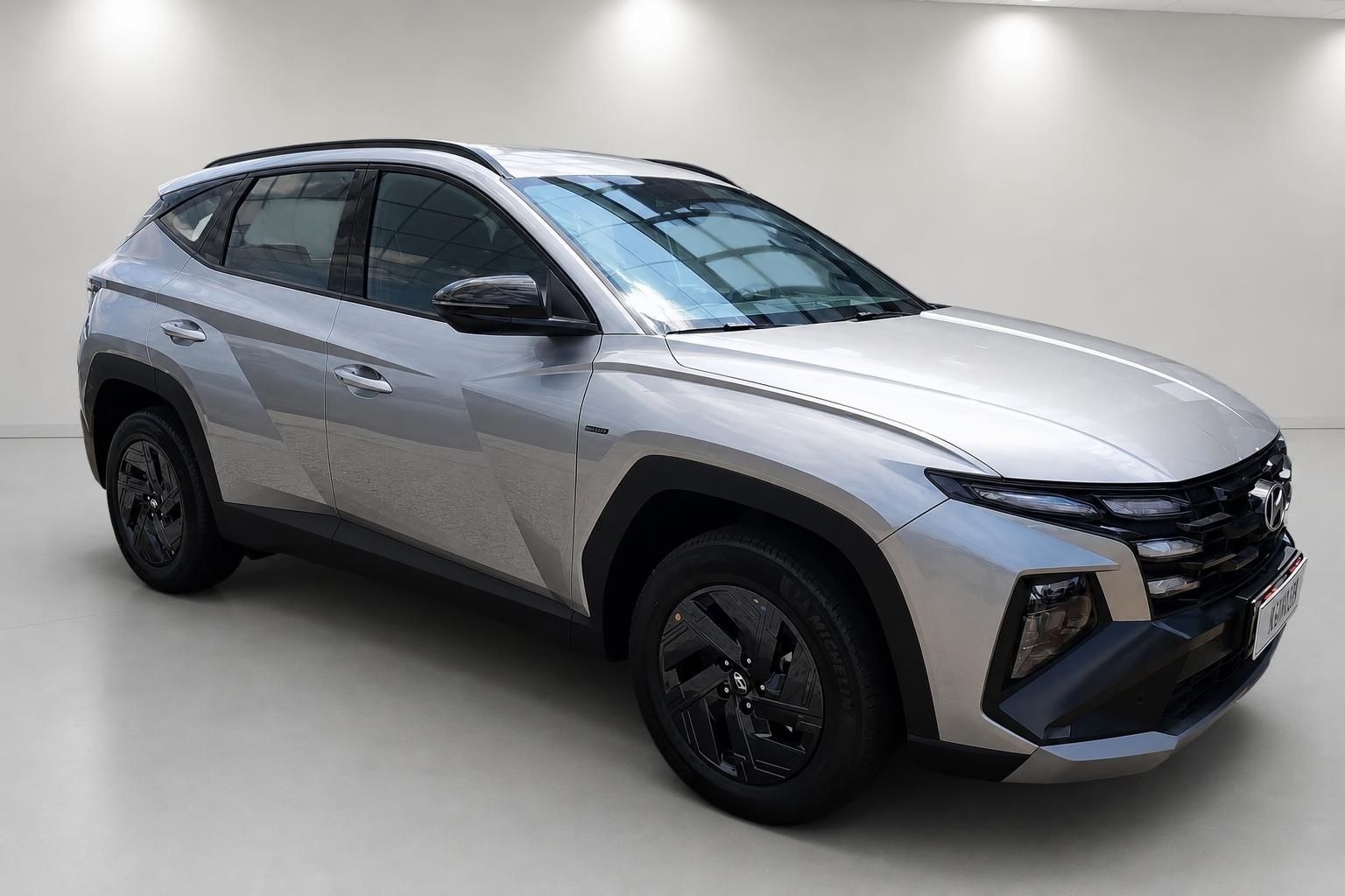 Hyundai Tucson SUV in Silber, Frontansicht schraeg im Showroom