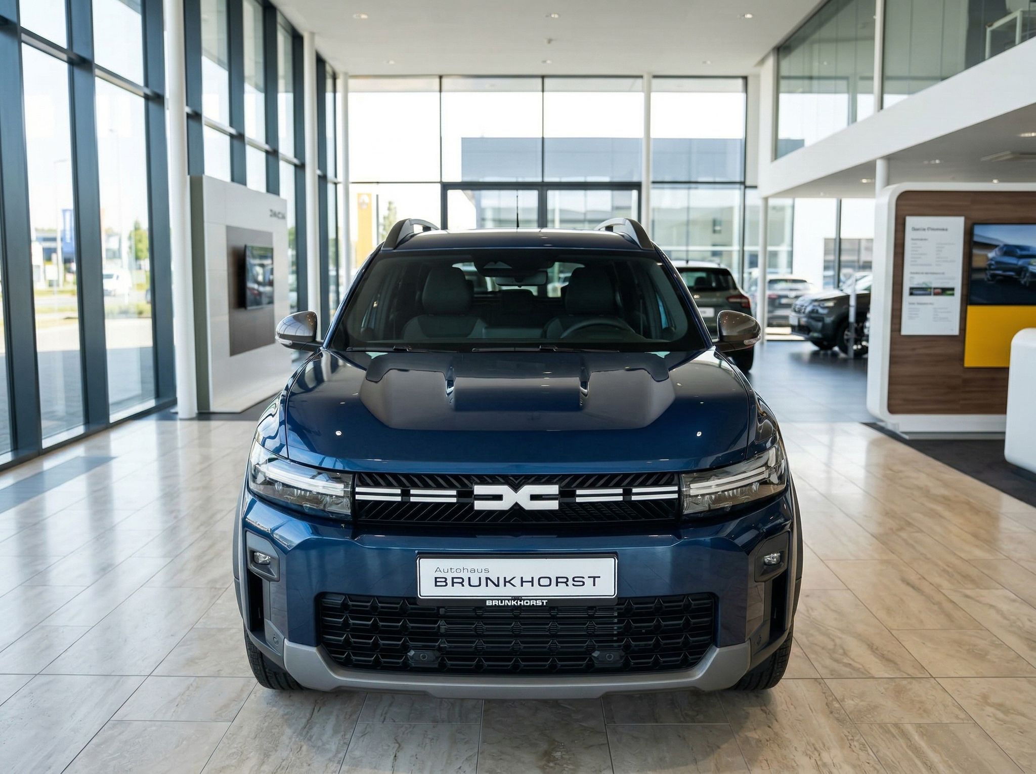 Dacia SUV Frontansicht in blau-grauer Lackierung im hellen Autohaus-Showroom
