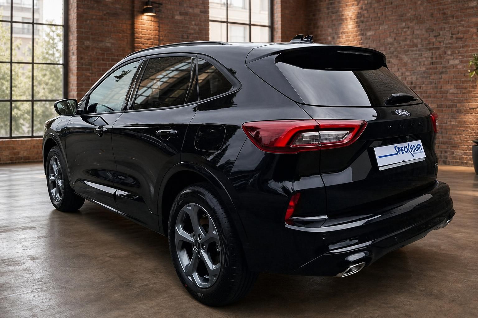 Ford Kuga schwarz Heckansicht in Loftambiente mit Backsteinwand