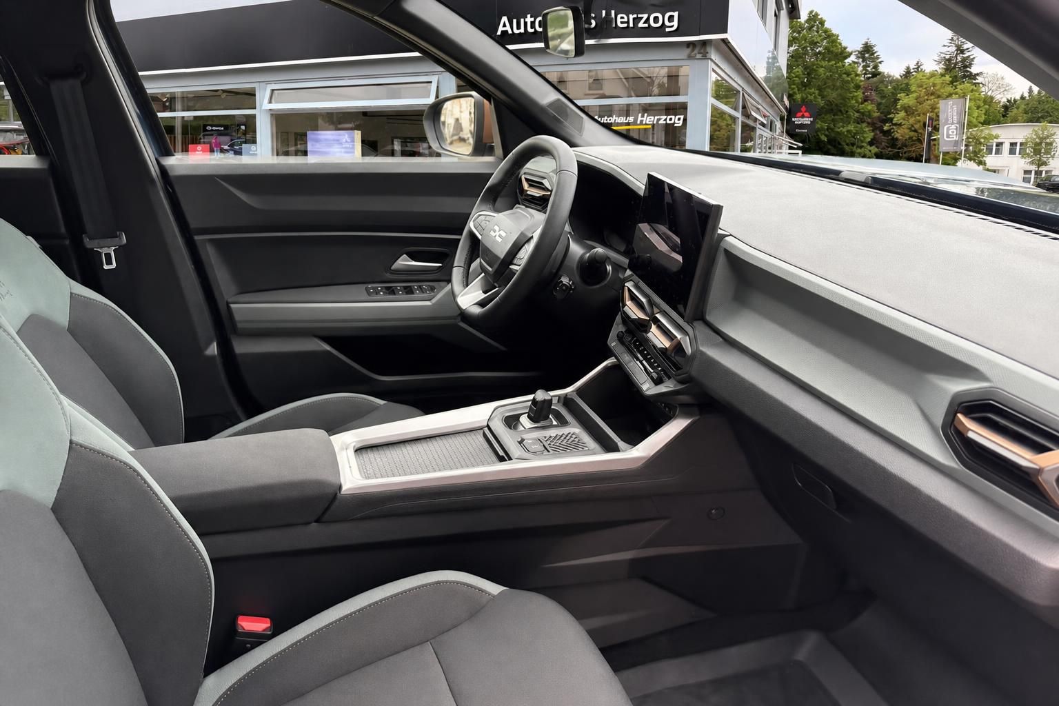 Dacia Bigster Innenraum Beifahrerseite mit Mittelkonsole, Schalthebel und Vordersitzen