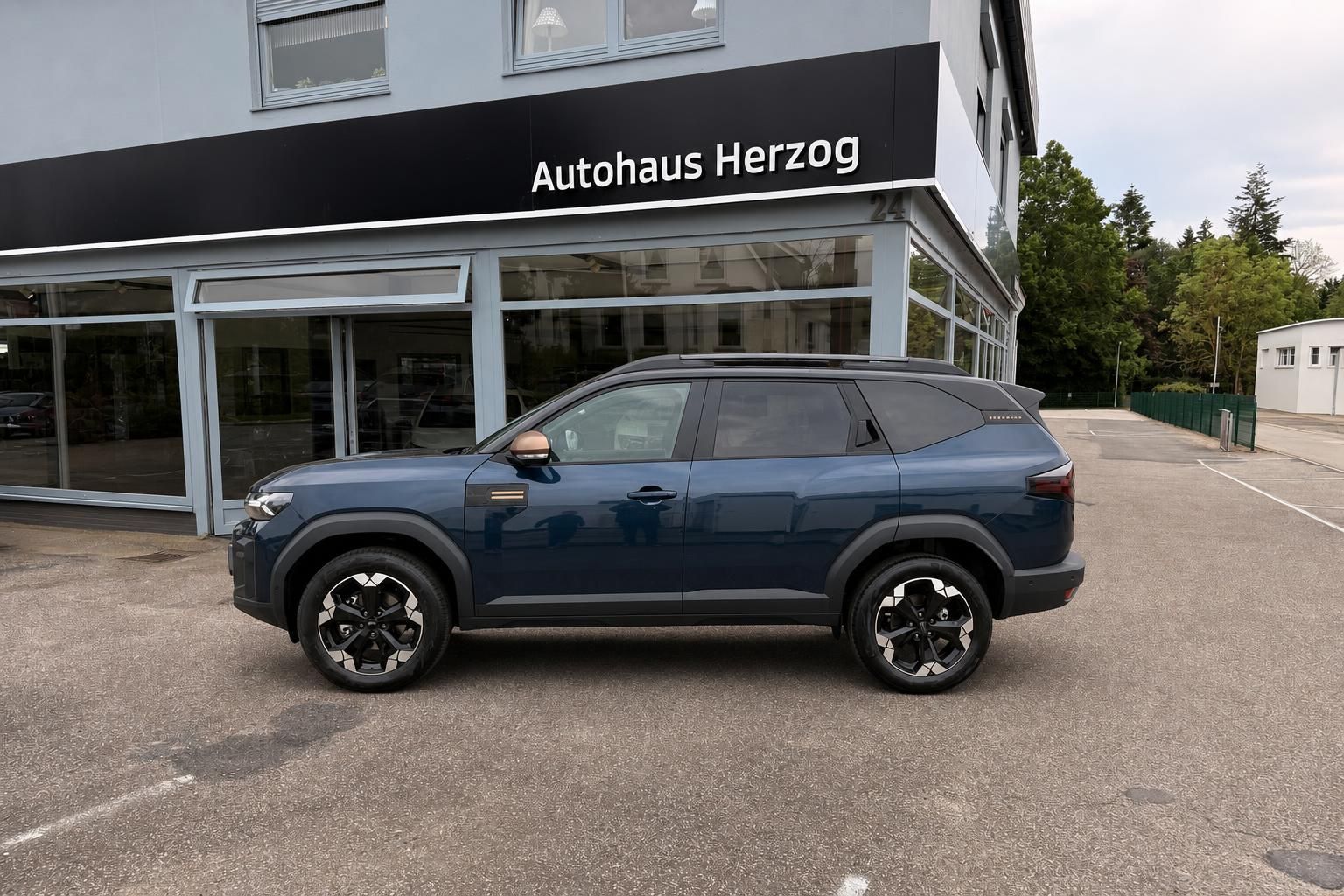 Dacia Bigster SUV blau Seitenansicht links vor Autohaus Herzog