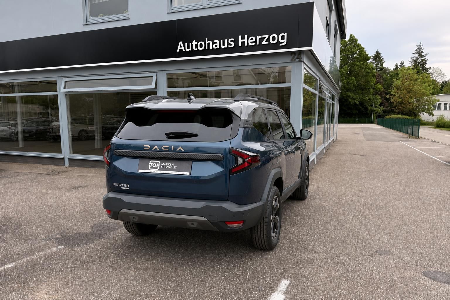 Dacia Bigster blau Heckansicht schräg rechts vor Autohaus Herzog
