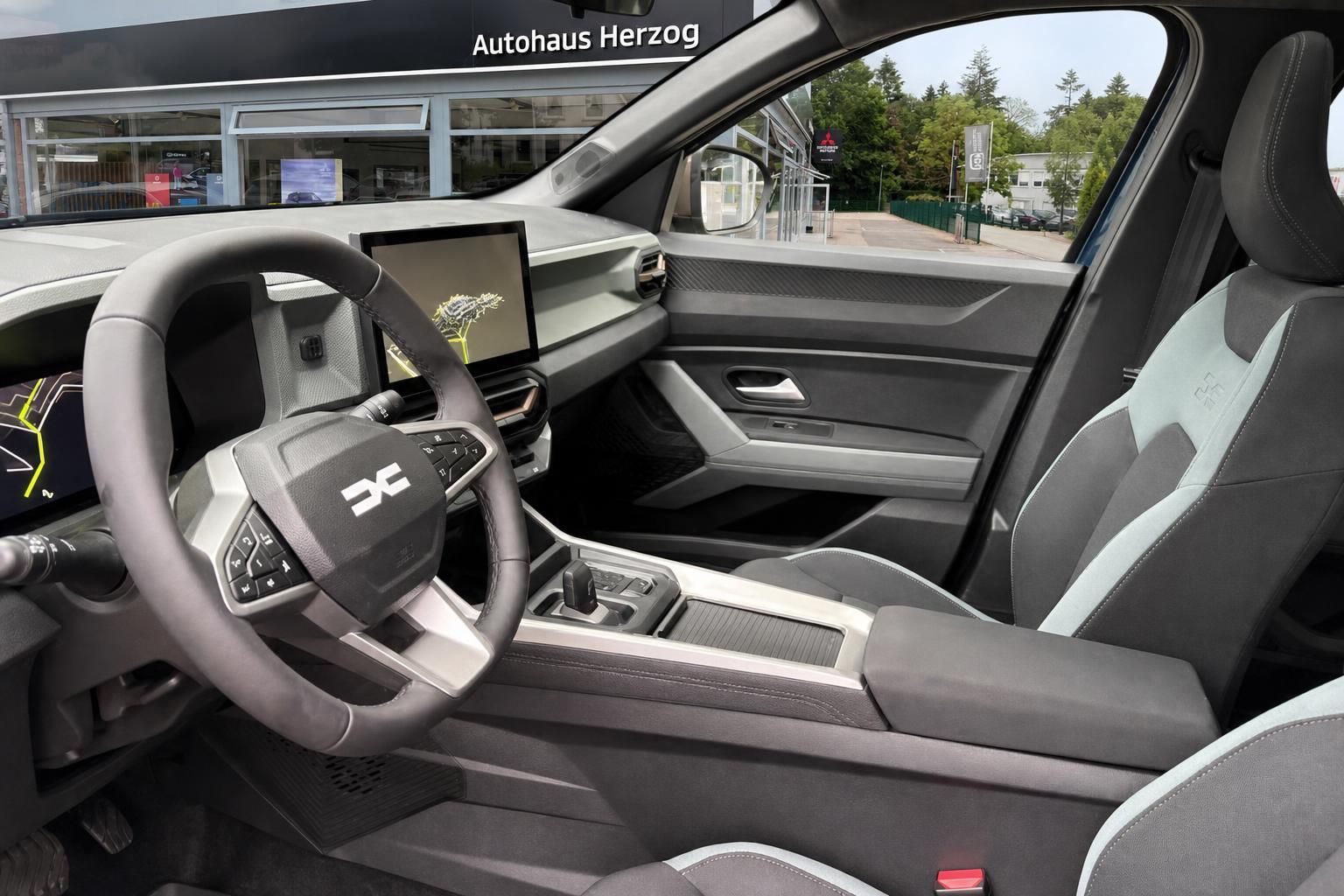 Dacia Jogger Innenraum – Cockpit mit Lenkrad, Touchscreen und Stoff-Ledersitzen in Grau-Mint