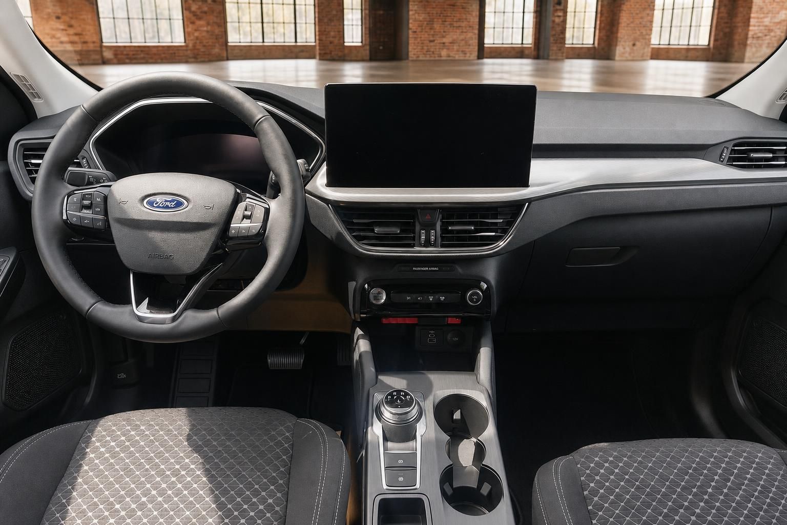 Ford Cockpit mit Lenkrad, zentralem Touchscreen, Mittelkonsole und Stoffsitzen in Schwarz