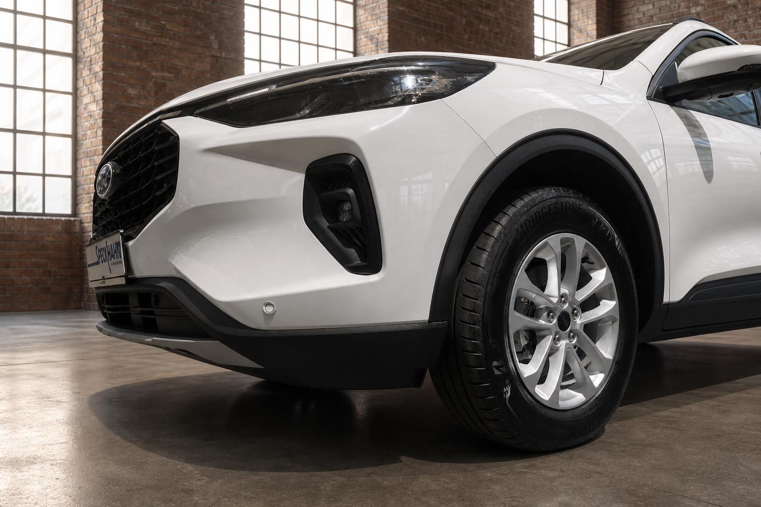 Ford Kuga weißer SUV Detailansicht Frontpartie mit Scheinwerfer und Bridgestone-Bereifung