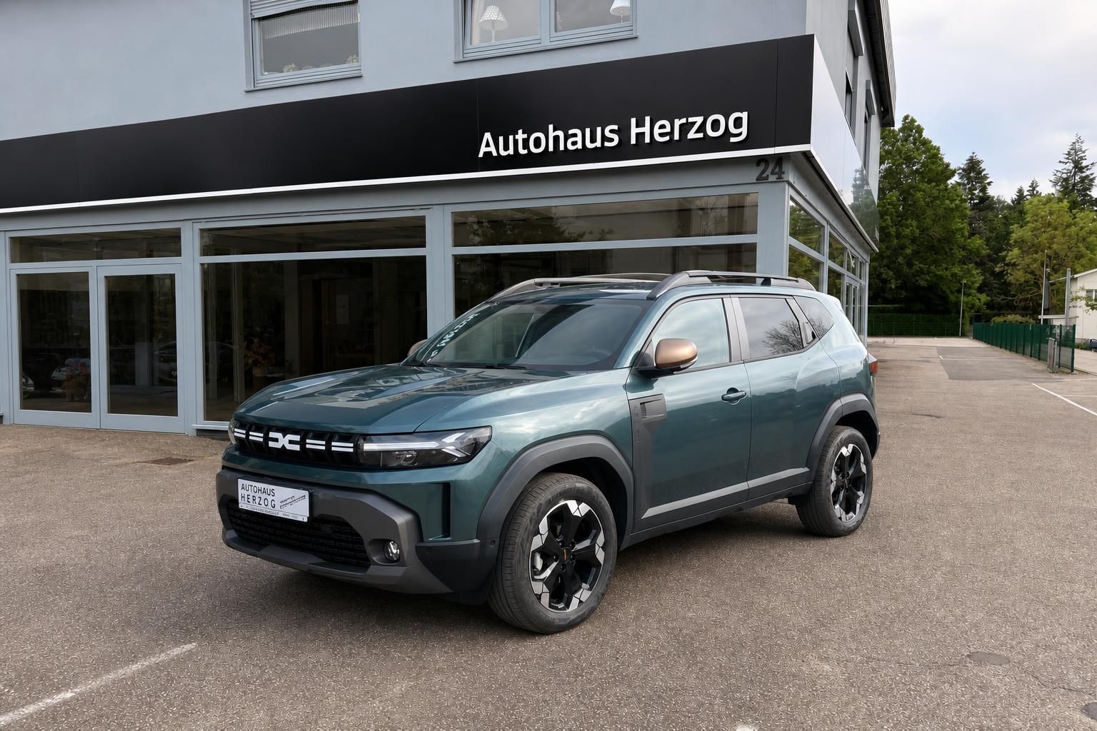 Dacia Duster SUV grün, Frontansicht mit markanter Kühlergrill - moderner Crossover vor Autohaus