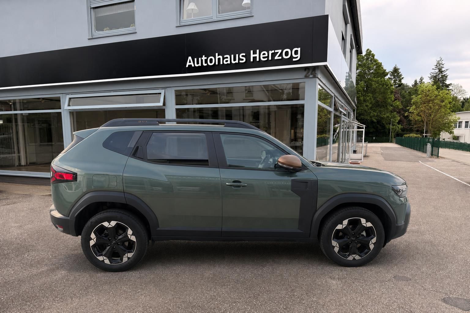 Grauer SUV Dacia Seitenansicht - Fahrzeug vor Autohaus Herzog geparkt