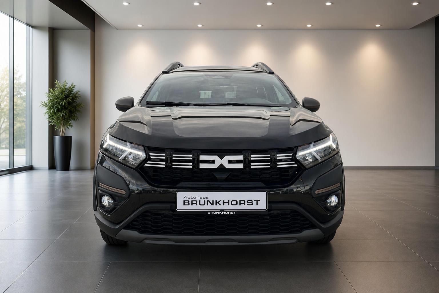 Dacia Jogger Frontansicht schwarz mit markanter Kühlergrill im Showroom