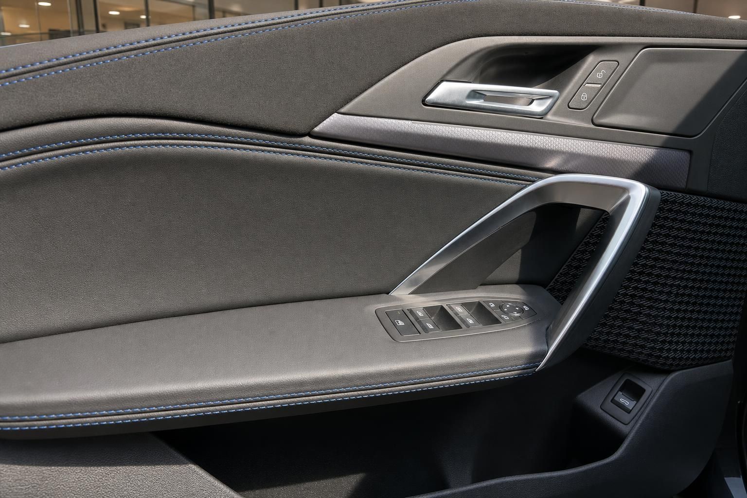 Türverkleidung mit Fensterhebern und blauer Kontrastnaht im BMW Innenraum