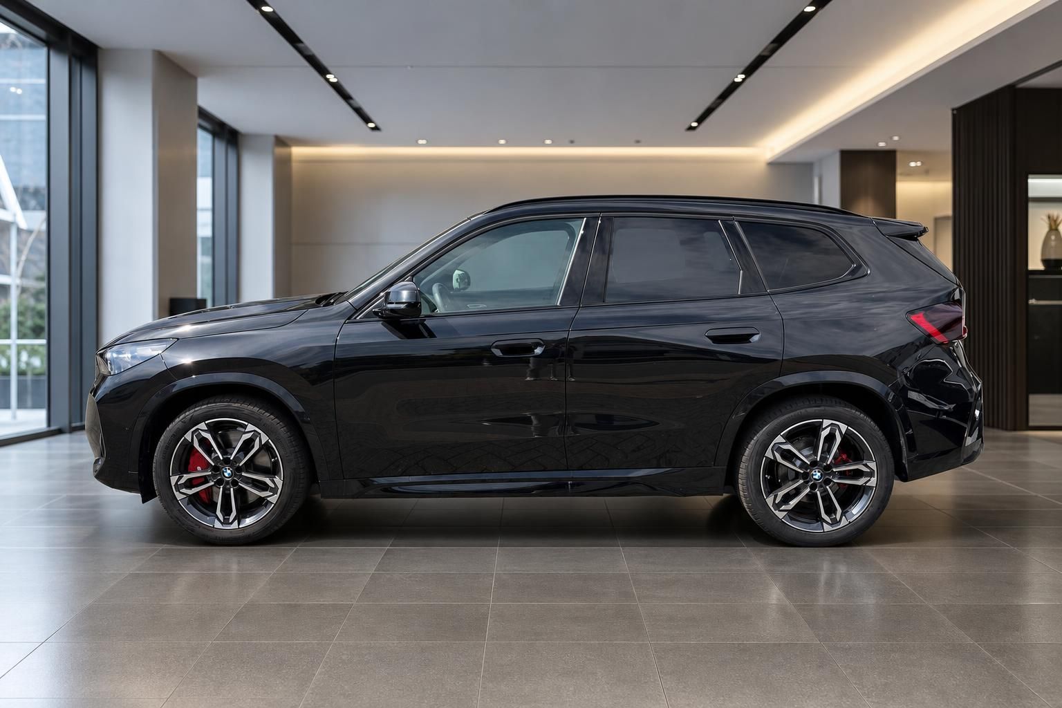 BMW X1 schwarz Seitenansicht im Autohaus Showroom