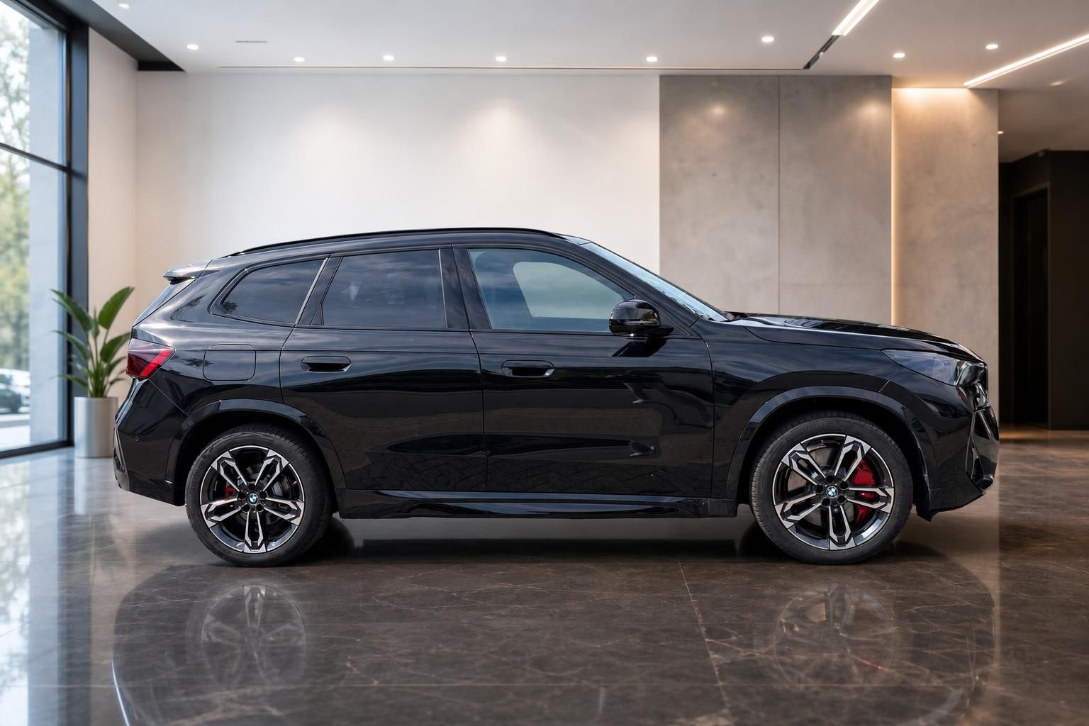 BMW X1 schwarz Seitenansicht mit M Sport Felgen im Showroom