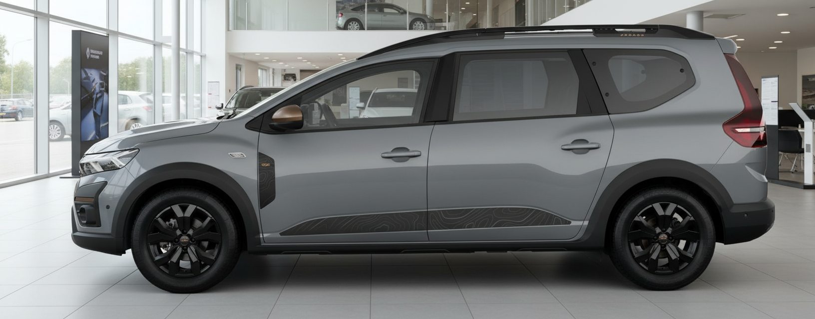 Dacia Jogger in Grau im Autohaus – Seitenansicht mit schwarzen Felgen und Biton-Dach