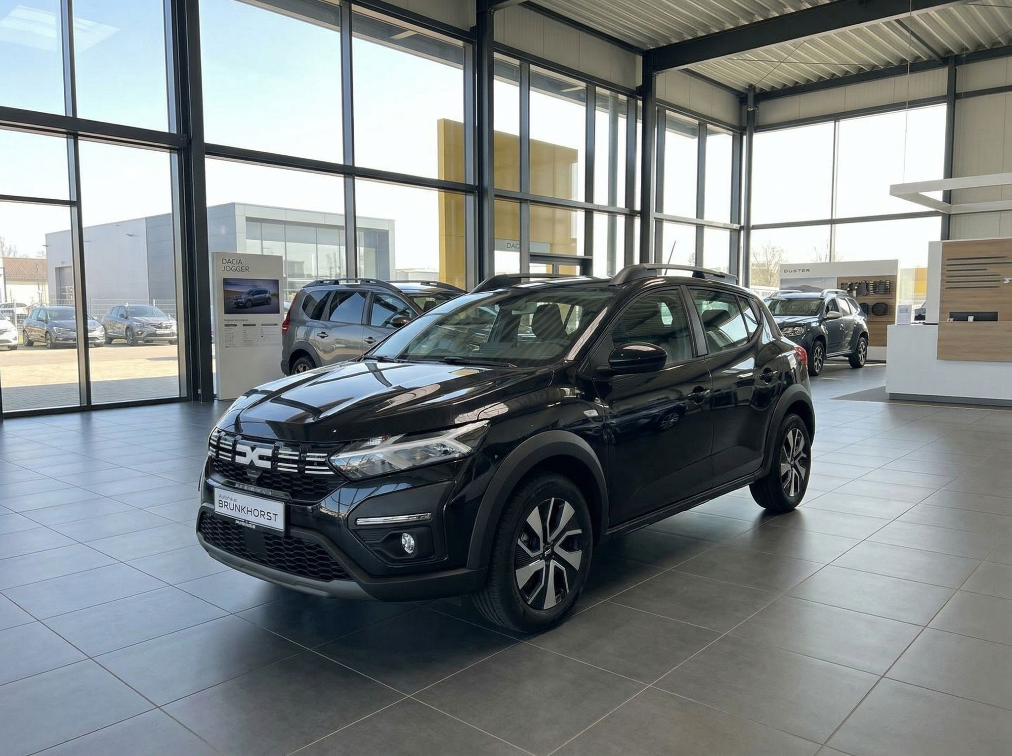 Schwarzer Dacia SUV Frontansicht im Autohaus Showroom mit modernem Interieur