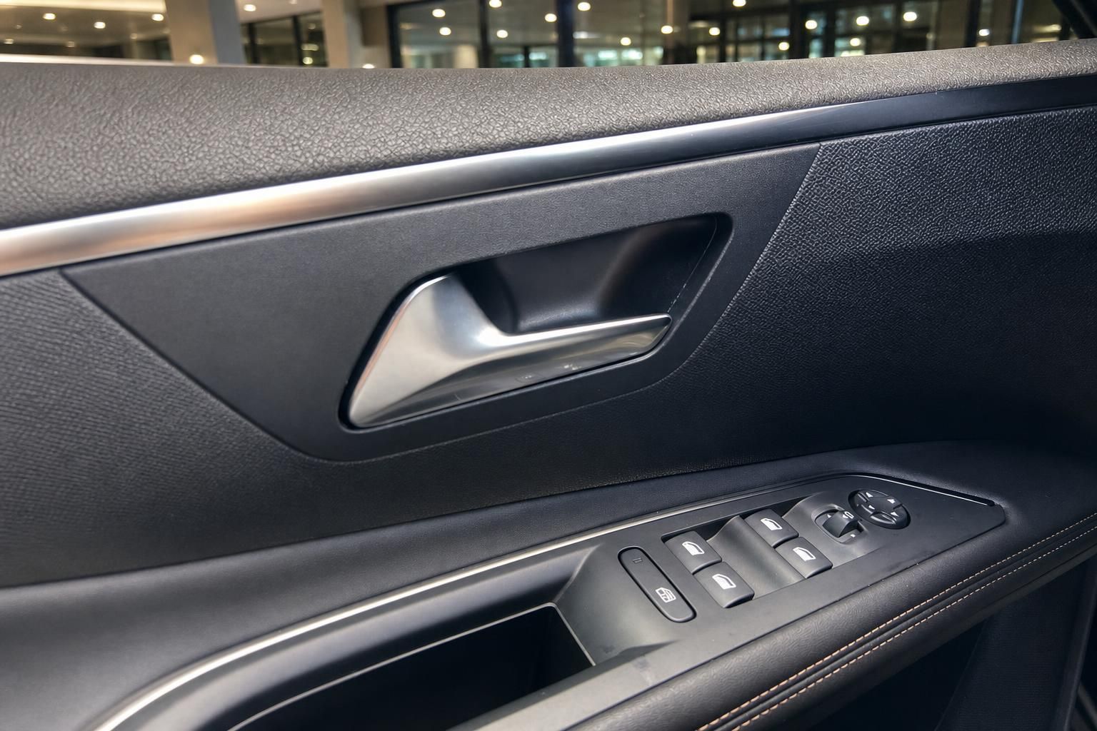 Peugeot Fahrertür innen mit elegantem Türgriff, Fensterheber und Spiegelverstellung in Detailaufnahme