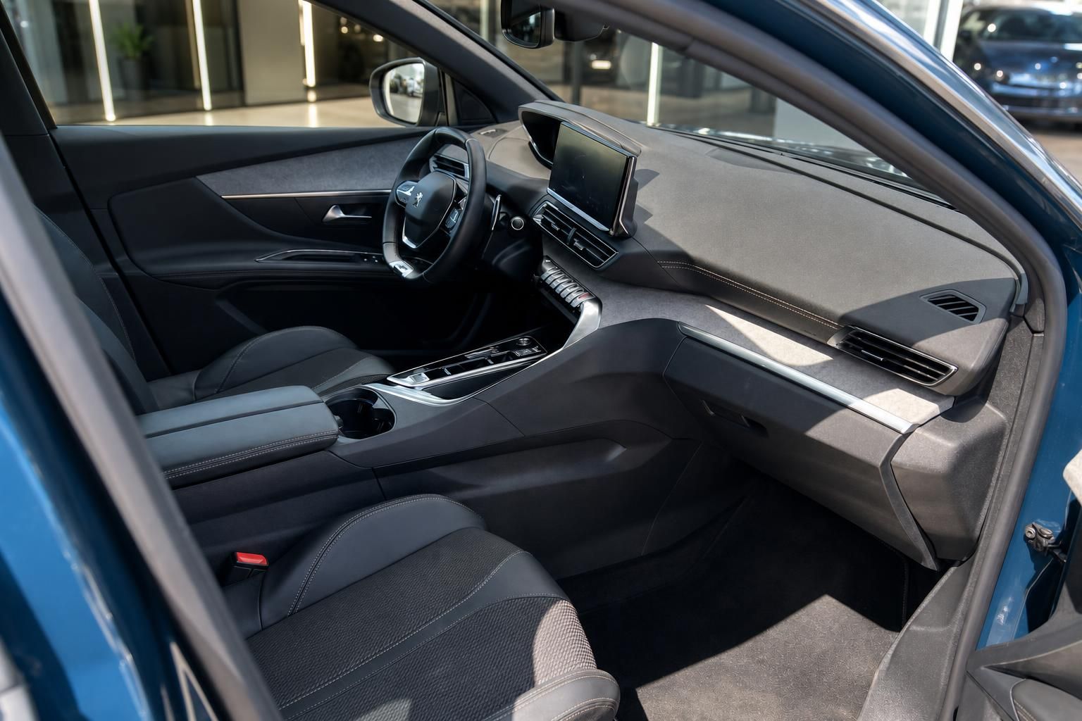 Peugeot Innenraum Beifahrerseite mit Touchscreen, Mittelkonsole und schwarzen Ledersitzen im Autohaus