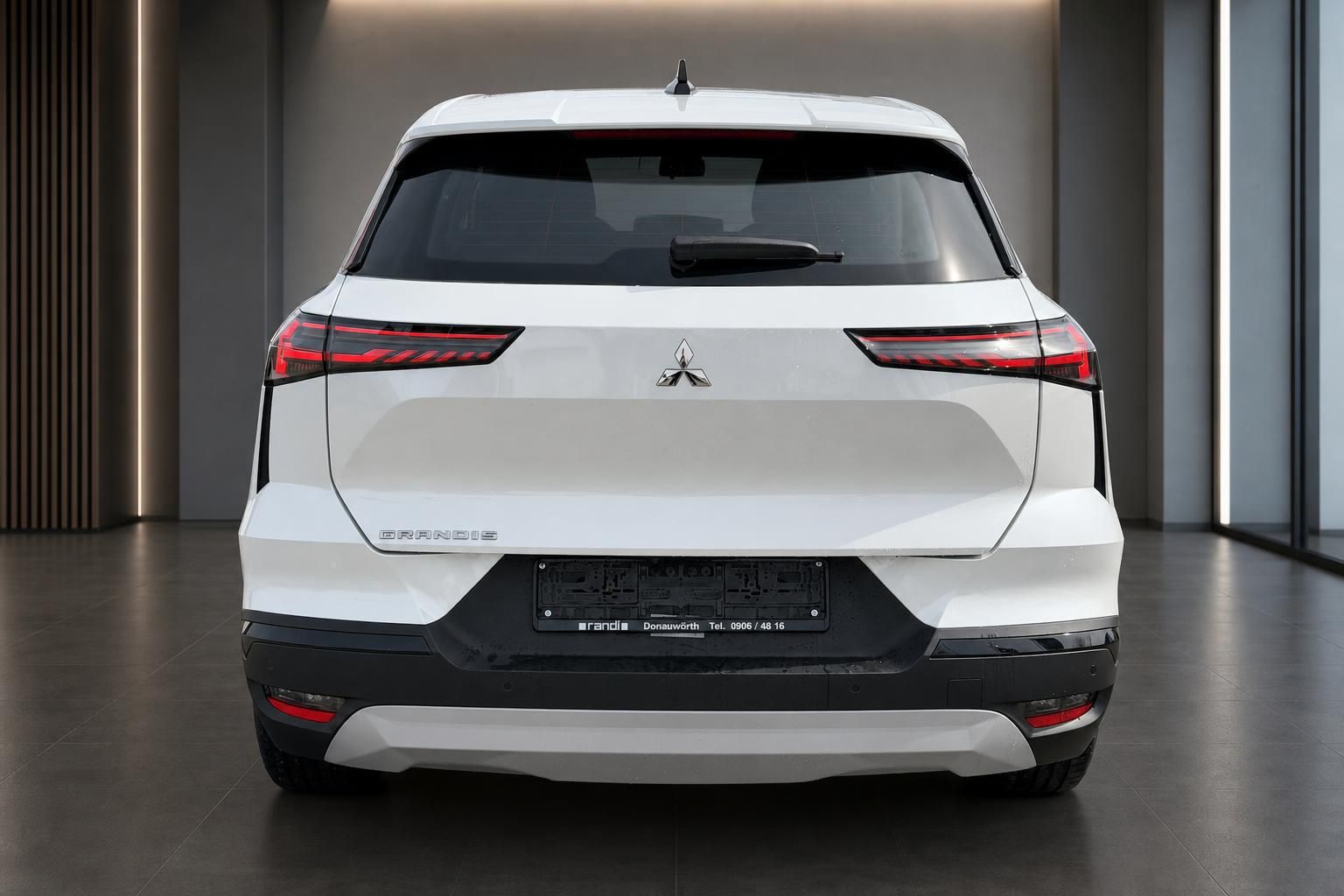 Mitsubishi Grandis weißer SUV direkte Heckansicht mit LED-Rückleuchten und Grandis Schriftzug im Showroom