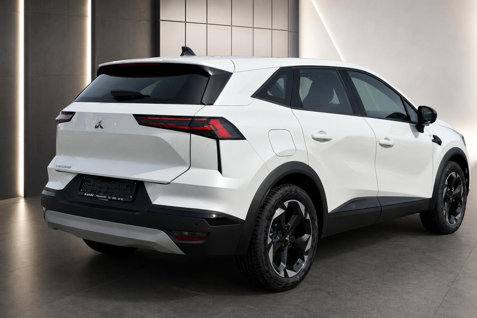 Mitsubishi Grandis weißer SUV Heckansicht schräg im Showroom mit markanten LED-Rückleuchten