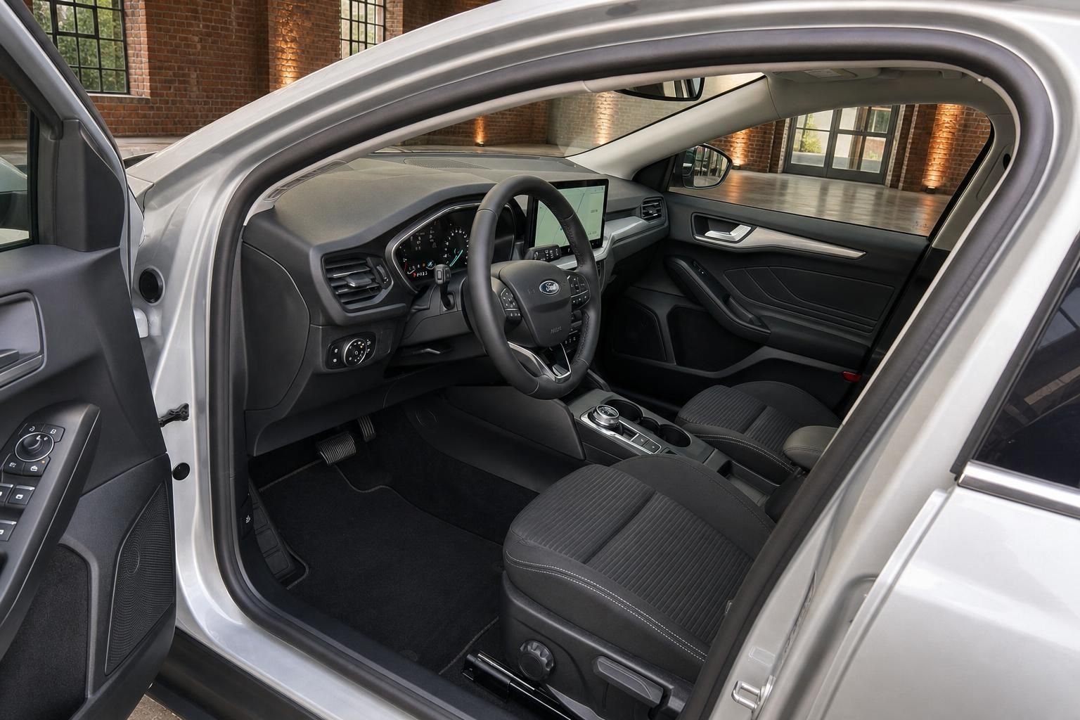 Ford Focus Innenraum mit Cockpit, Lenkrad und Vordersitzen bei geöffneter Tür