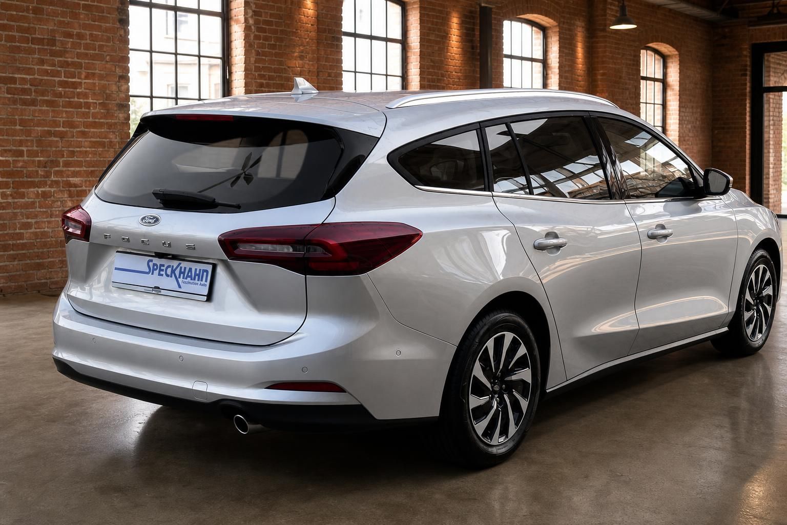 Ford Focus Turnier silber Heck- und Seitenansicht vor Fensterfront