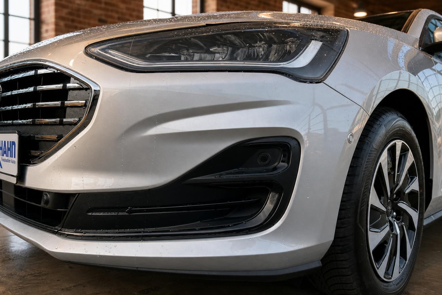 Ford Focus silber Detailansicht Frontscheinwerfer und Stoßfänger im Regen