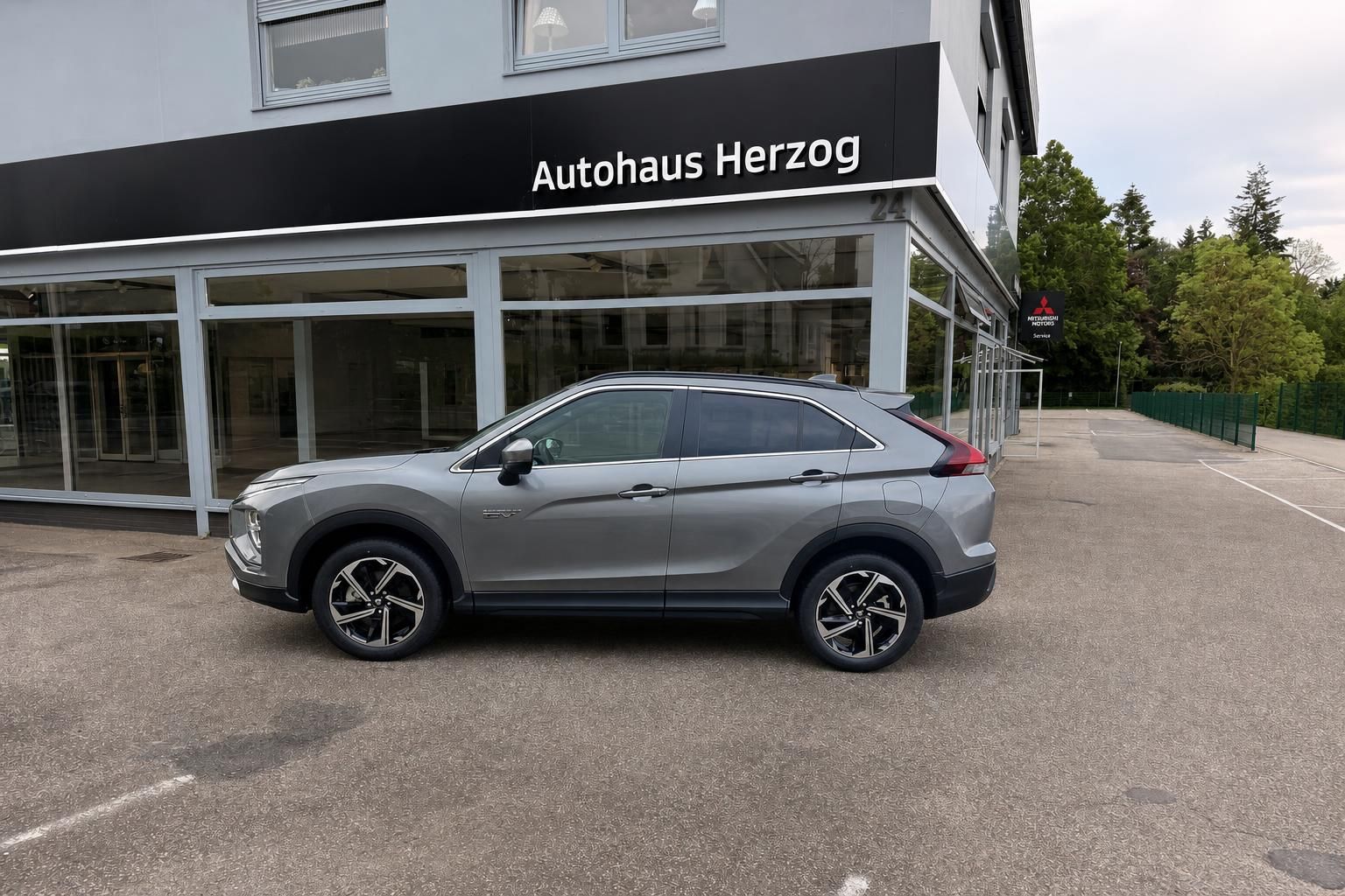 Mitsubishi Eclipse Cross SUV in grau, Seitenansicht mit modernen Leichtmetallfelgen im Autohaus-Showroom