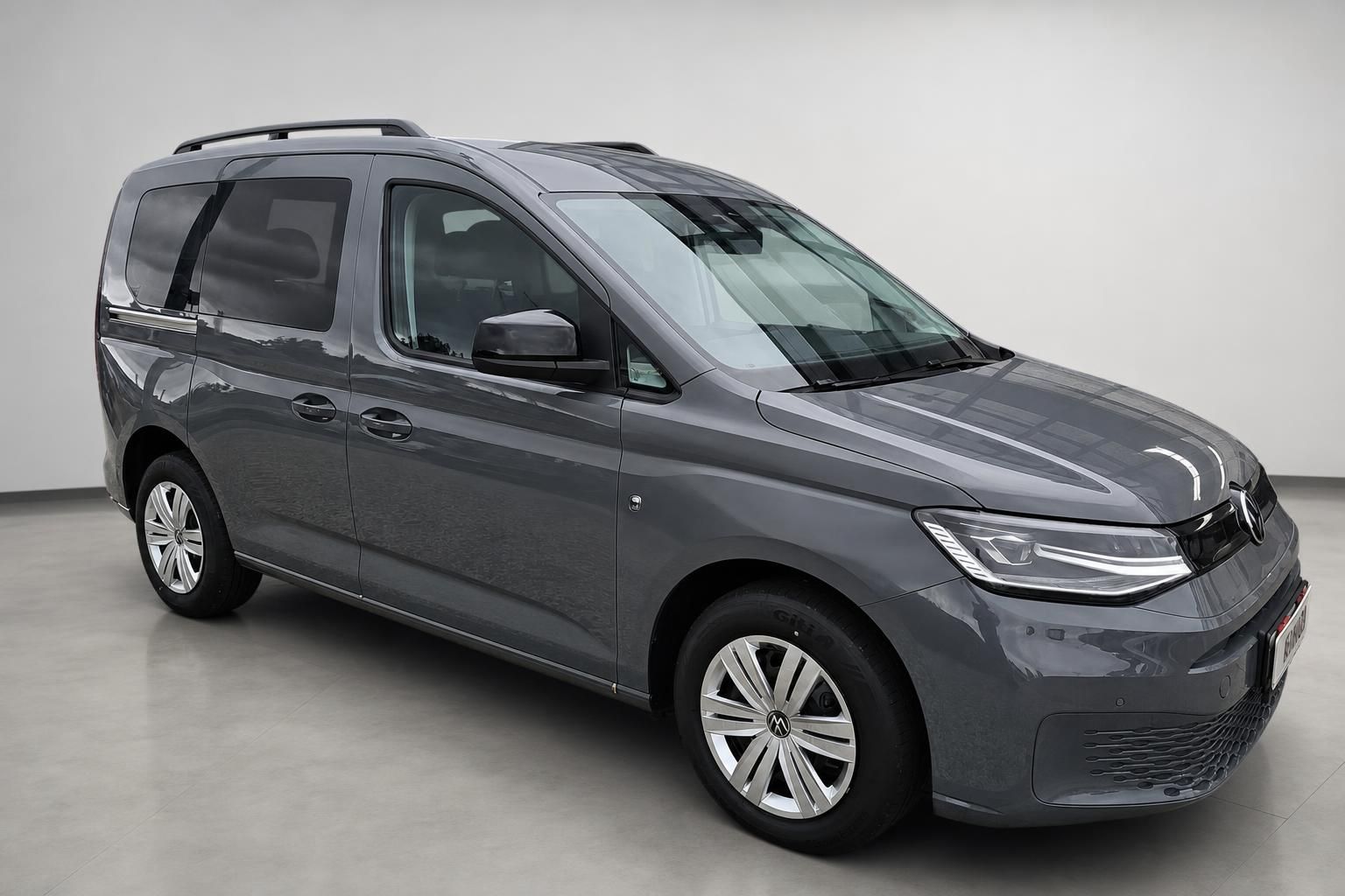 VW Caddy grau metallic Seitenansicht schraeg vorne im Studio