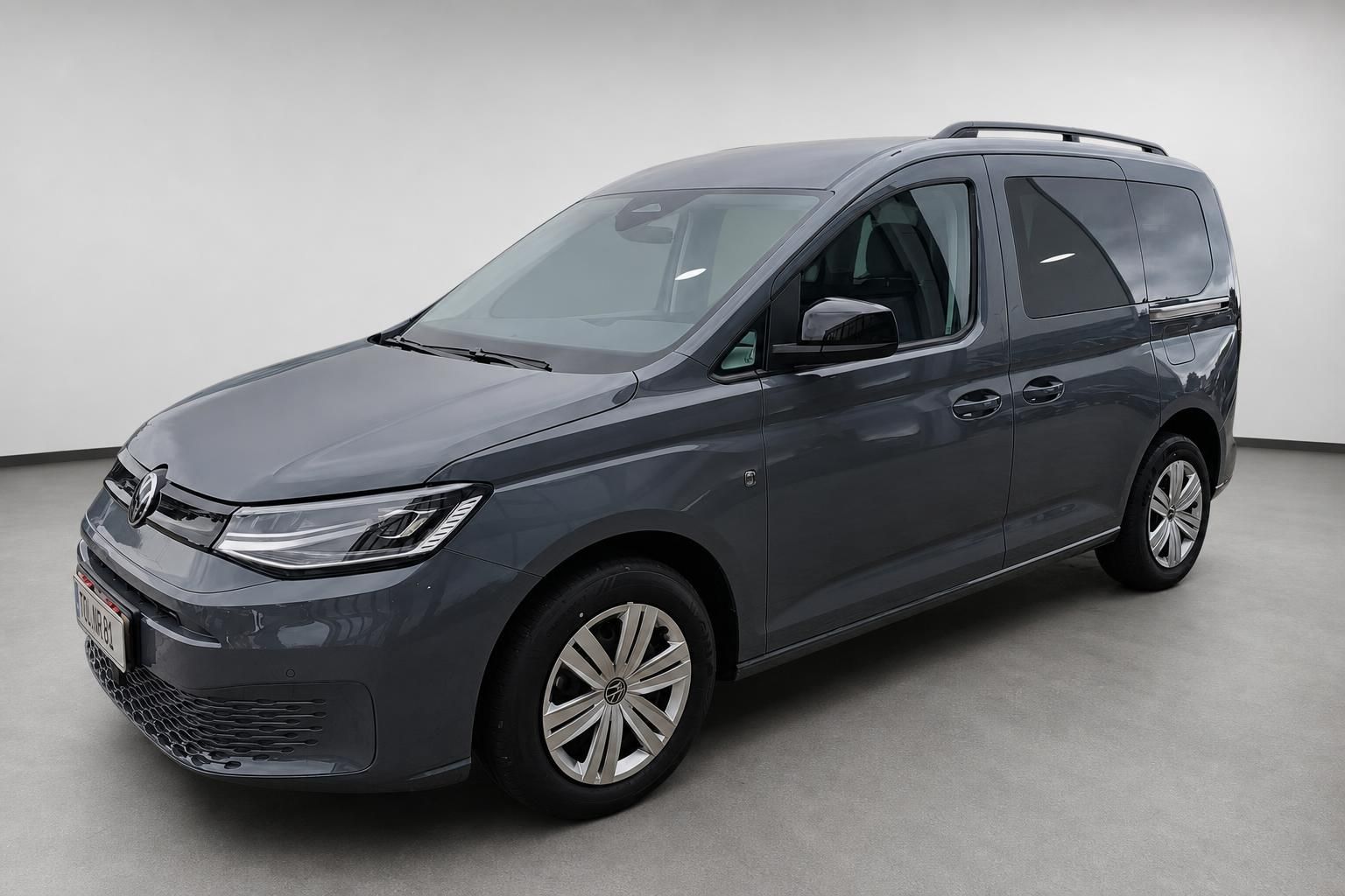 VW Caddy dunkelgrau Frontansicht schraeg Studioaufnahme
