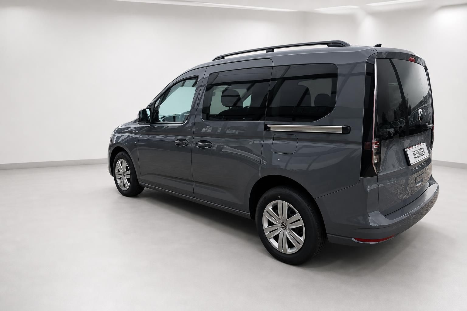 VW Caddy in Grau, Heckansicht seitlich im Studio