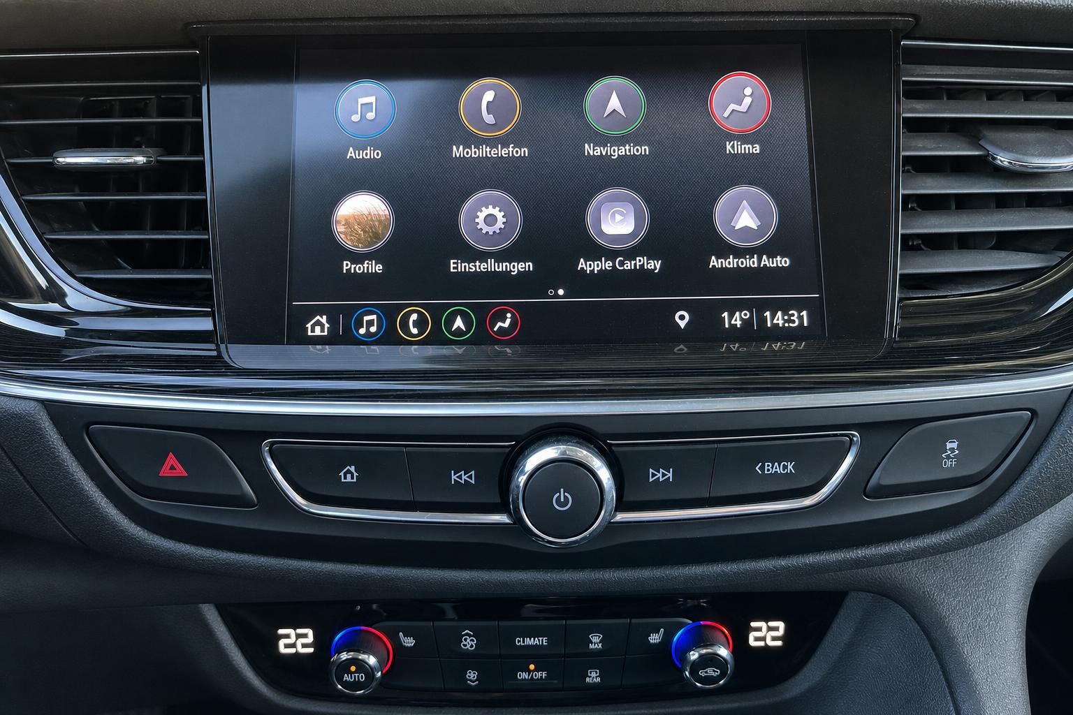 Modernes Infotainment-System mit Touchscreen und Klimaregler im Fahrzeug-Innenraum