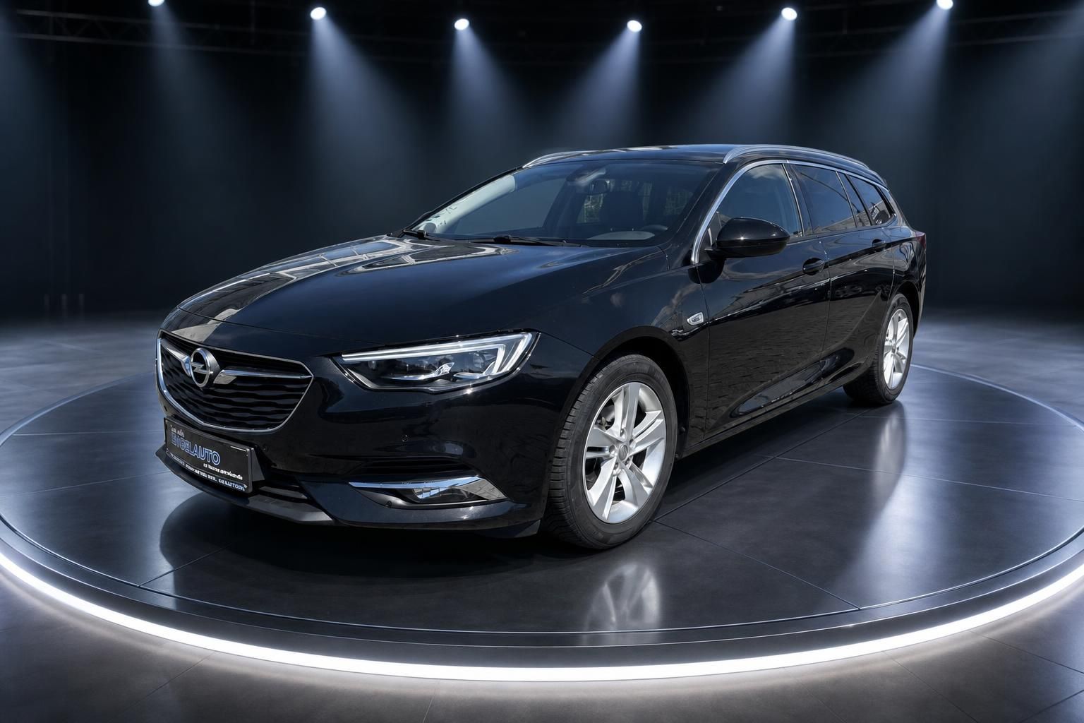 Schwarzer Opel Insignia Sports Tourer Kombi in der Seitenansicht vor dunklem Hintergrund