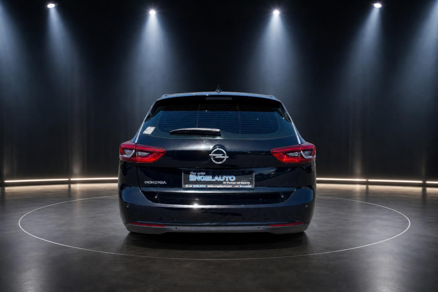 Schwarzer Opel Insignia Kombi Heckansicht mit Händlerkennzeichen auf drehbarer Plattform