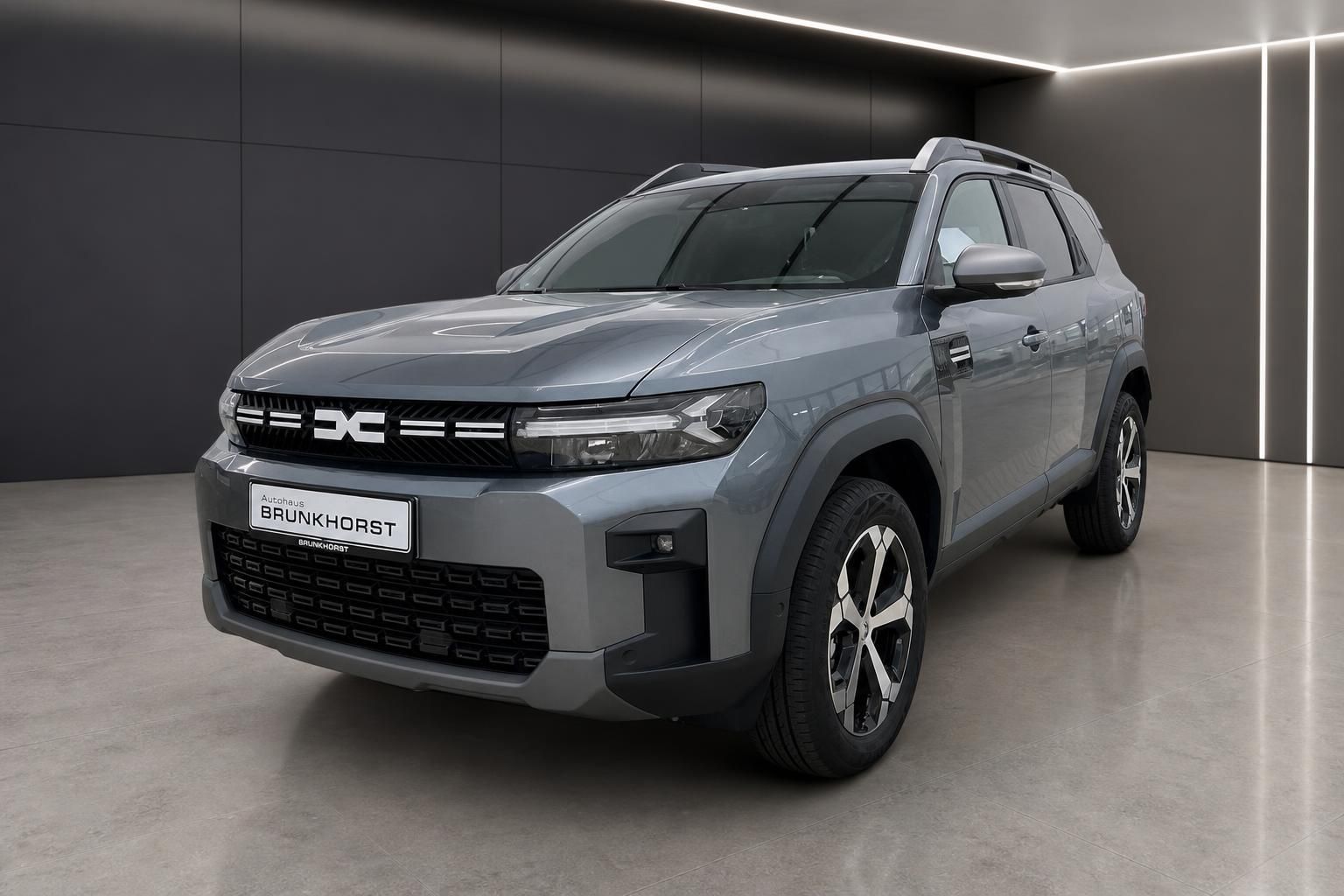 Dacia Bigster SUV in grau - Frontansicht im modernen Showroom