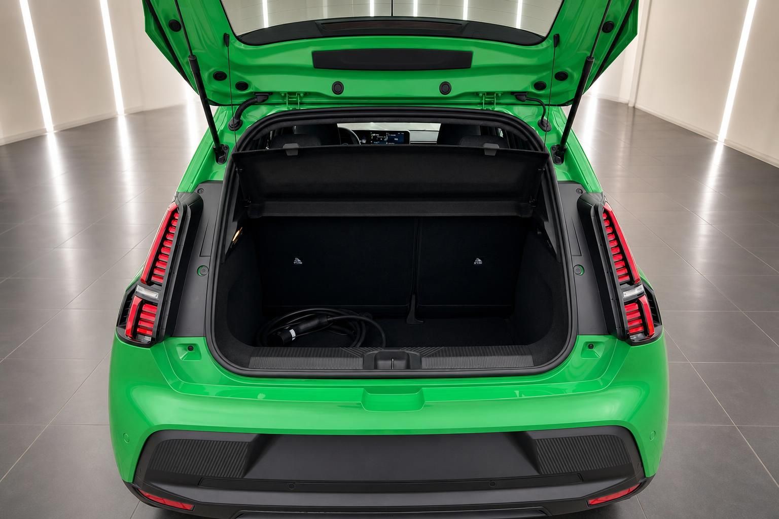 Grüner Elektro-SUV Kofferraum geöffnet mit Ladekabel – geräumiger Laderaum von hinten