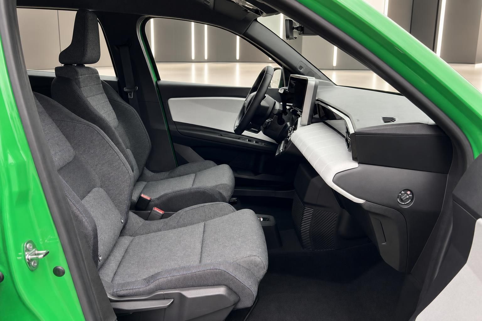 Grünes Elektroauto Innenraum Vordersitze mit Lenkrad und Armaturenbrett seitlich