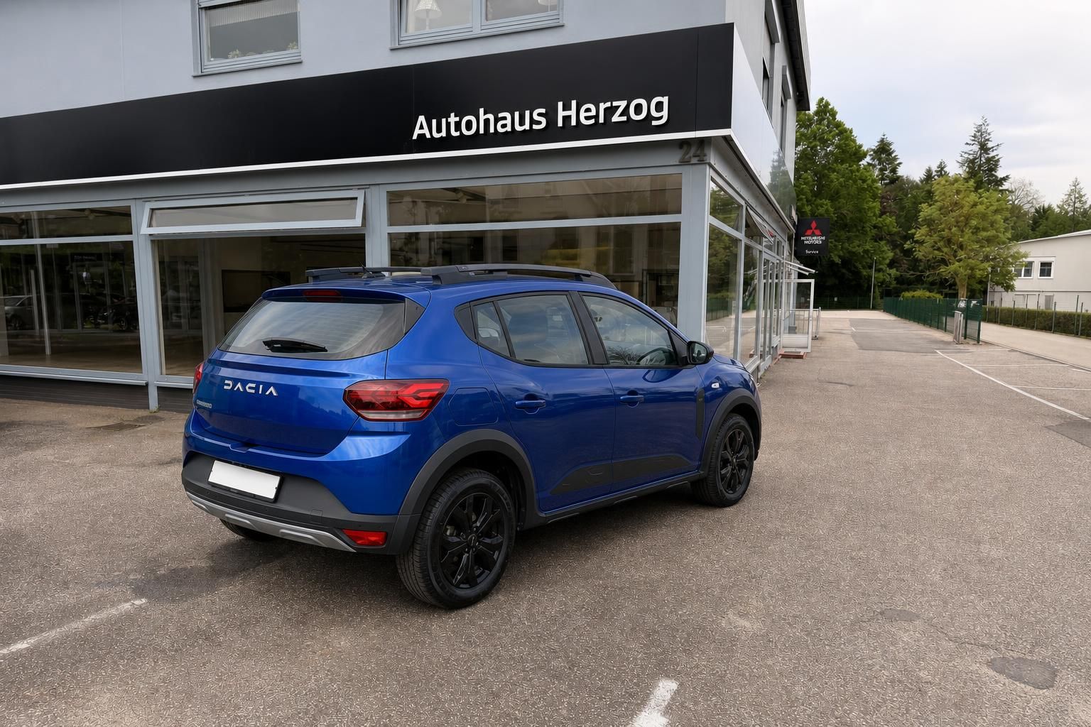 Blauer Dacia Stepway SUV Heckansicht schräg hinten beim Autohaus Herzog