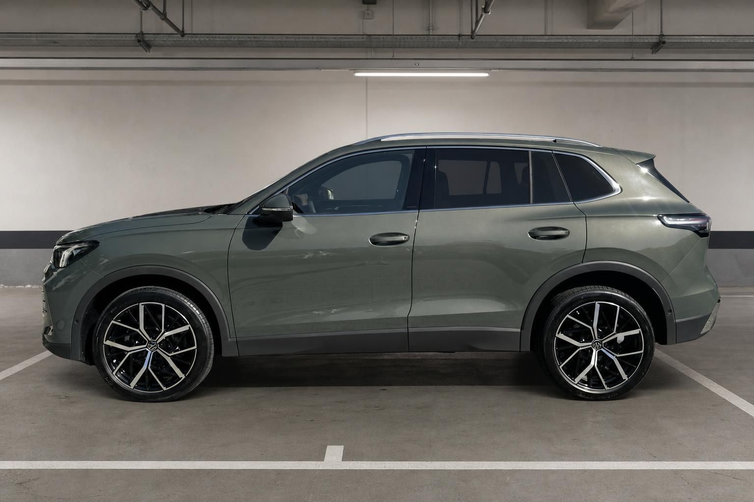 VW Tiguan olivgrün Seitenansicht links in Parkhaus – SUV mit Panoramadach und Sportfelgen