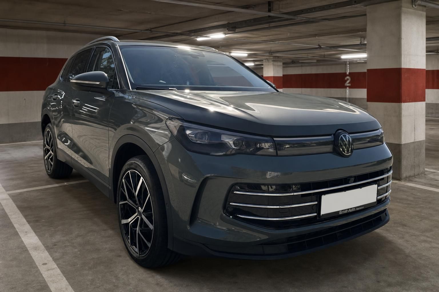 VW Tiguan grau Frontansicht schräg links im Parkhaus – SUV mit Chromgrill und Sportfelgen