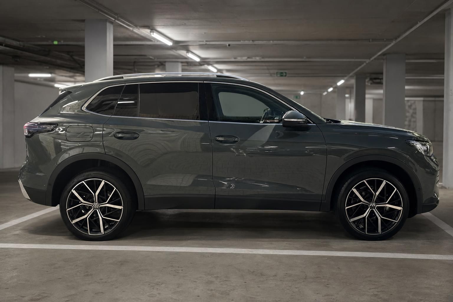 VW Tiguan grau Seitenansicht links in Parkhaus – SUV mit schwarzen Leichtmetallfelgen