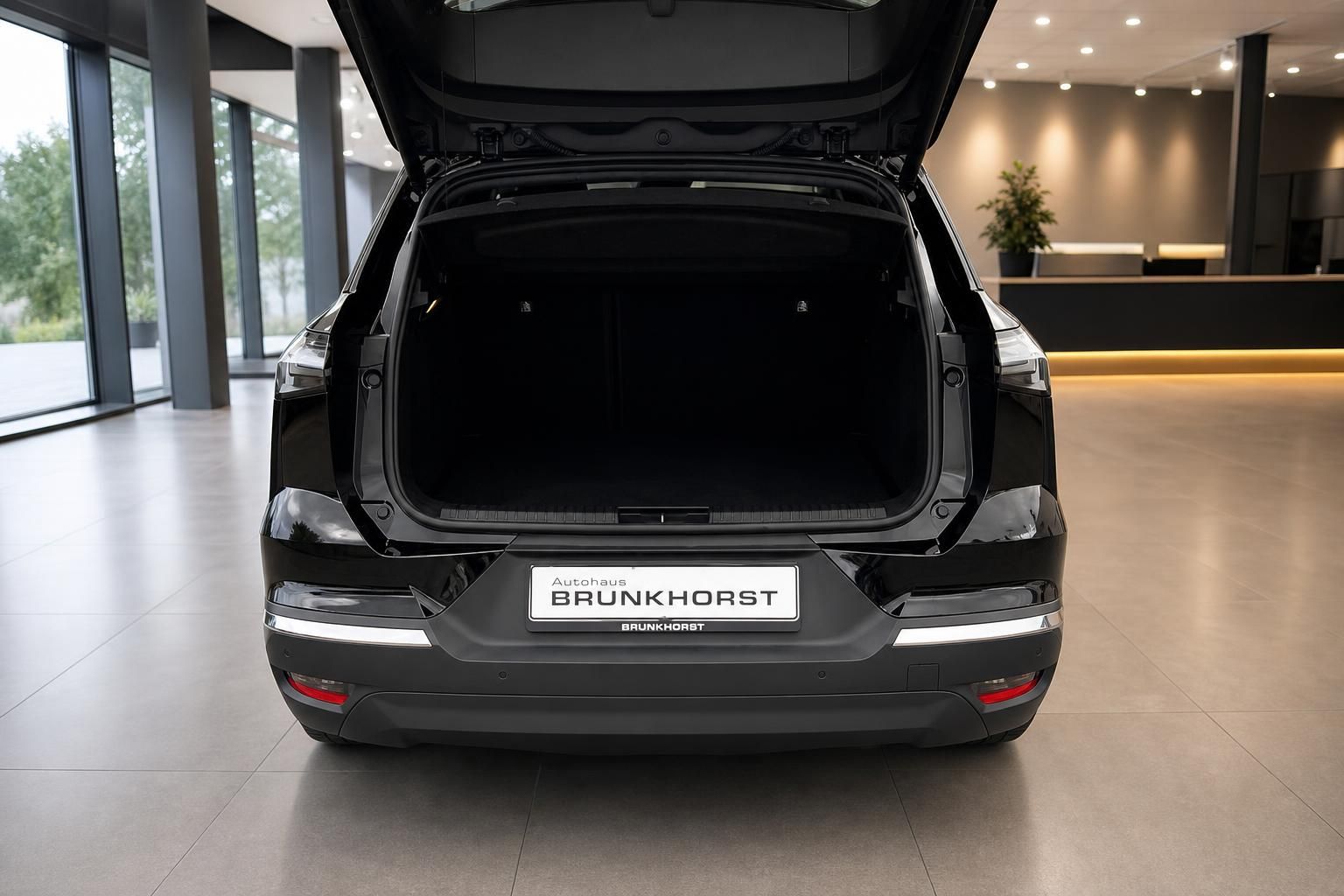 Schwarzes SUV mit geoeffneter Heckklappe und leerem Kofferraum im Autohaus