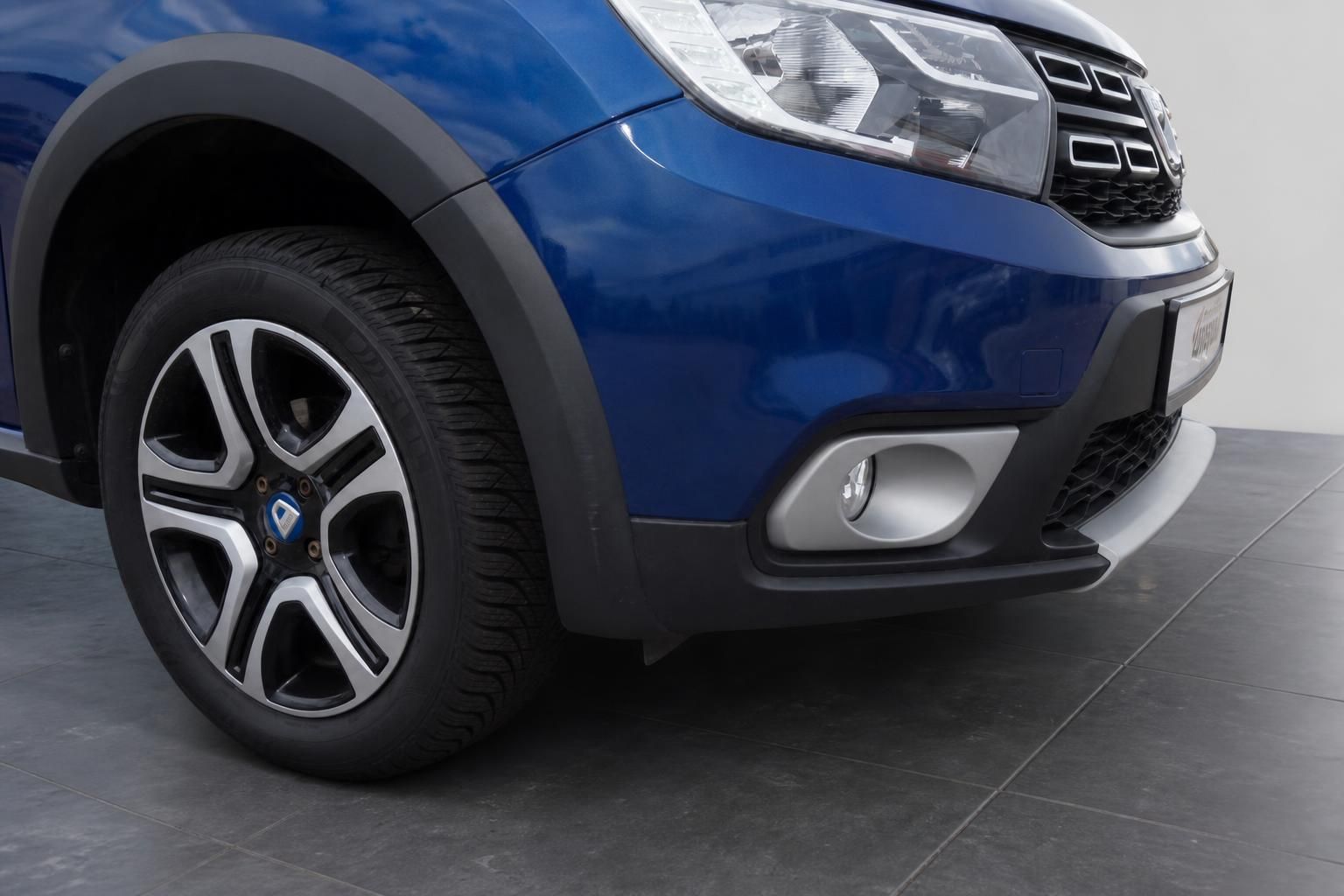 Dacia Sandero Stepway Detailaufnahme Vorderrad Leichtmetallfelge und Stoßfänger blau