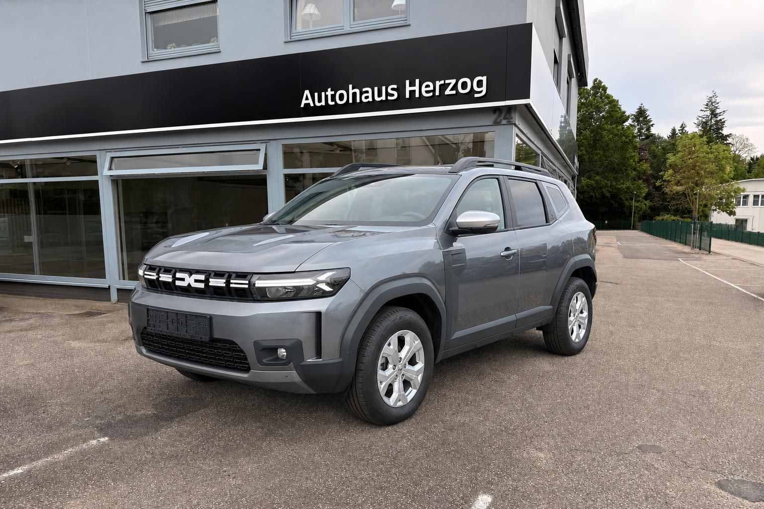 Dacia Duster SUV grau in Frontansicht vor Autohaus Herzog