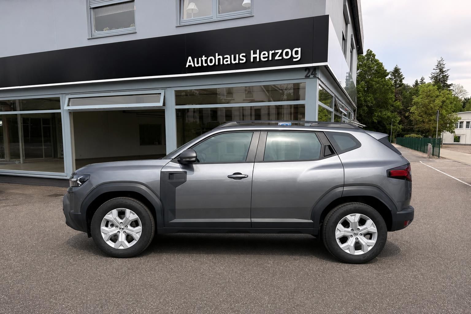 Dacia Duster grau Seitenansicht vor Autohaus Herzog