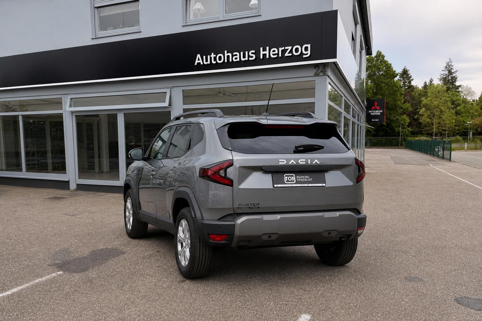 Dacia Duster grau Heckansicht mit Markenspezialist Schild