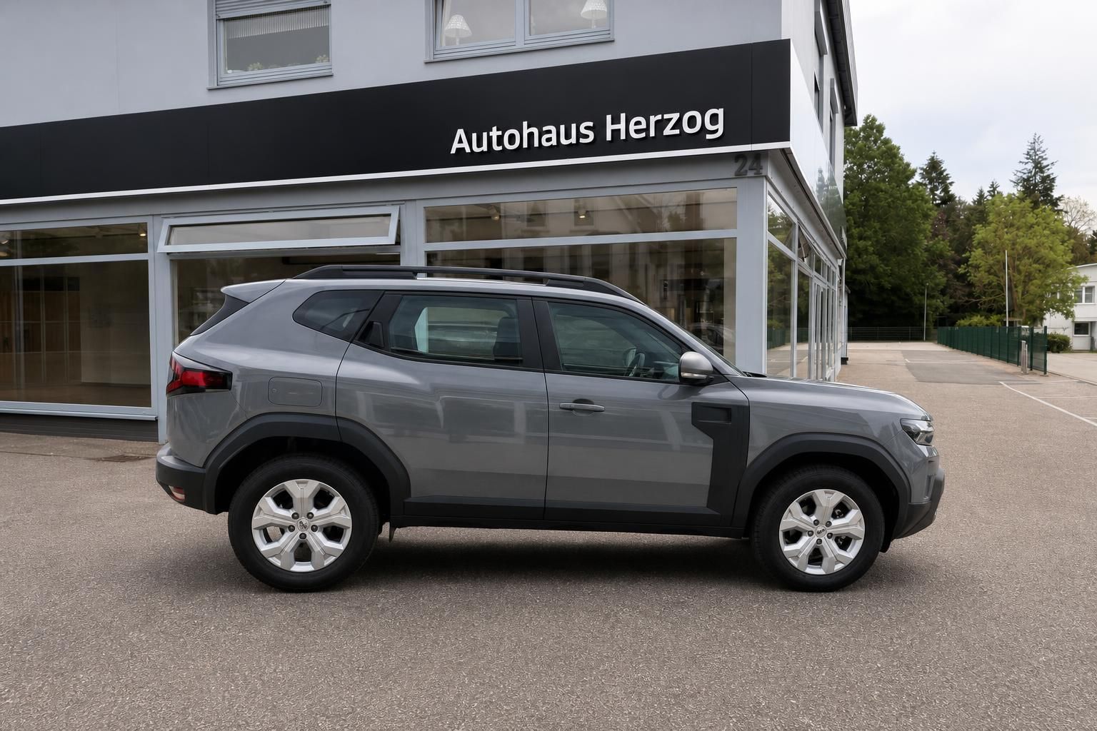 Dacia SUV grau Seitenansicht vor Autohaus Herzog