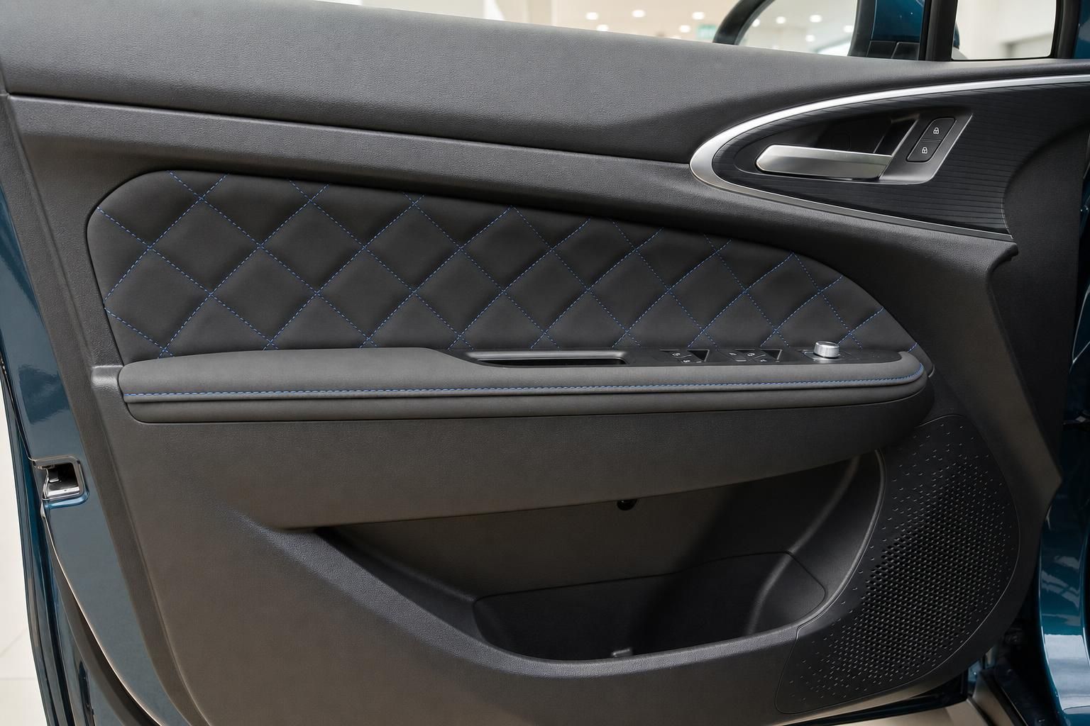 Türverkleidung mit Rautensteppung und blauer Ziernaht im Fahrzeuginnenraum