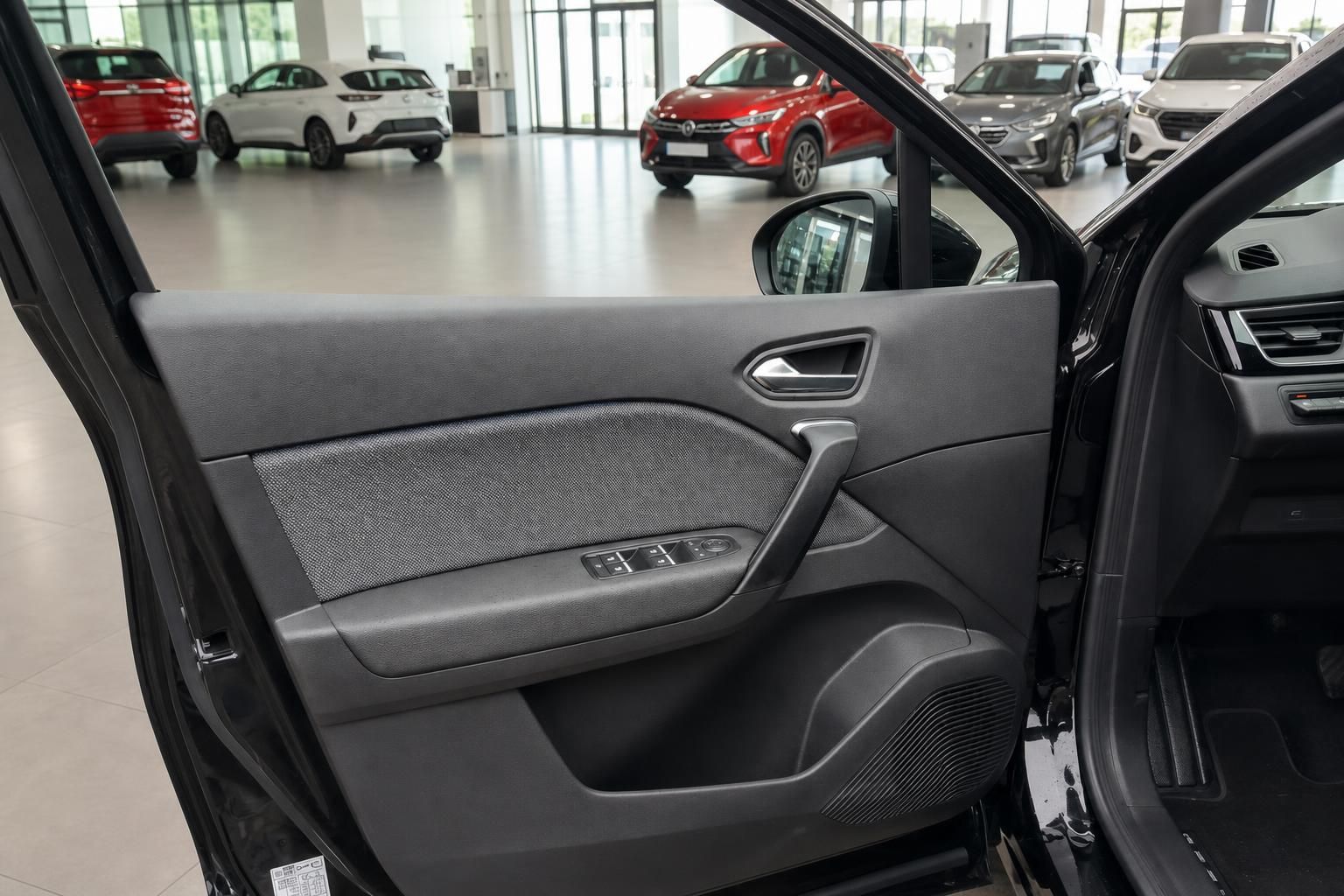 Fahrzeug-Innenraum mit geöffneter Fahrertür und Blick auf die Türverkleidung im Autohaus