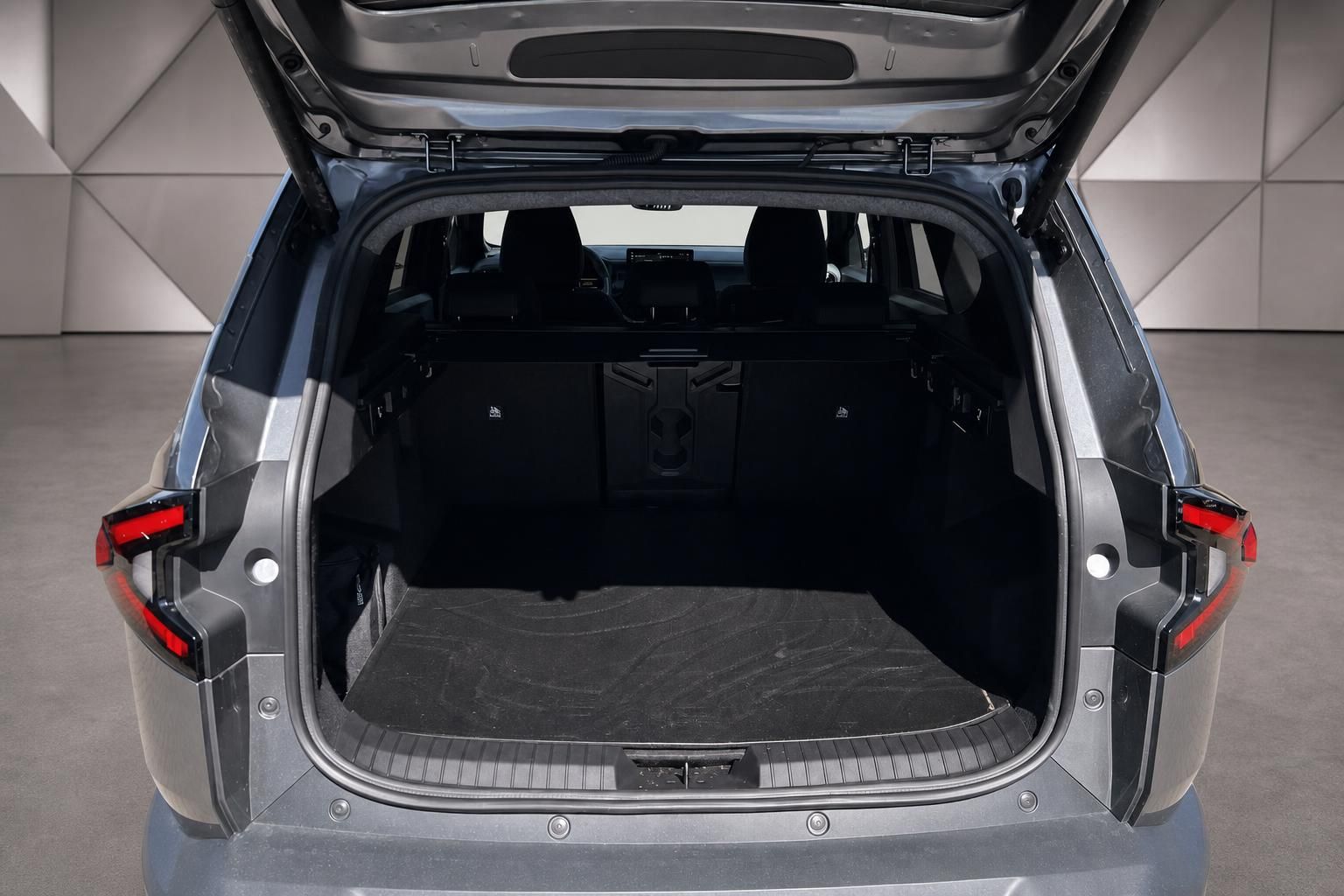 Kofferraum eines grauen SUVs mit geöffneter Heckklappe und schwarzer Innenausstattung